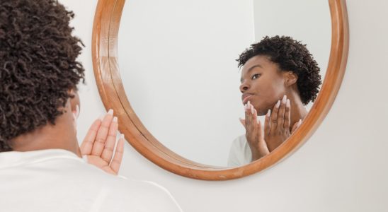 man wearing white shirt facing on wall mirror