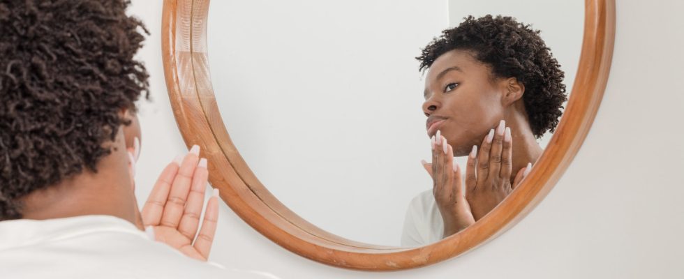 man wearing white shirt facing on wall mirror