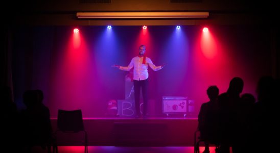 man in black shirt singing on stage